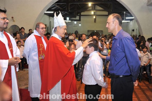 Momento en que el joven Juan Domingo Mendoza acompañado de su Padrino Julio Winckler recibe el Sacramento de la Confirmación del Monseñor Zacarías Ortiz, obispo de la diócesis de Concepción y Amambay. (Foto: Fotomanía Digital). 